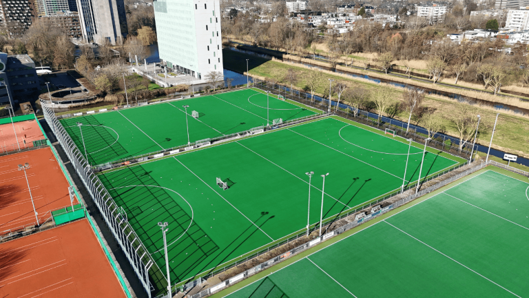 Aanleg twee nieuwe hockey watervelden bij AMVJ Amstelveen door Finovi. In opdracht van Gemeente Amsterdam. Hoge ballenvanger. Ballenvanger 8 meter hoog